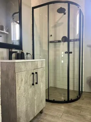 a glass shower in a bathroom with a sink at Kiewiets Creek Guesthouse in Pretoria