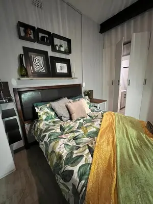 a bedroom with a bed with a green comforter at Kiewiets Creek Guesthouse in Pretoria