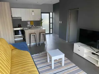 a living room with a couch and a kitchen at The Blues in Pretoria