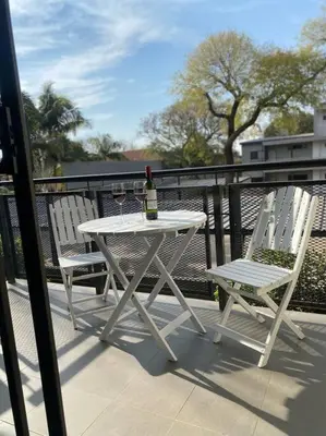 a white table and two chairs with a bottle of wine at The Blues in Pretoria
