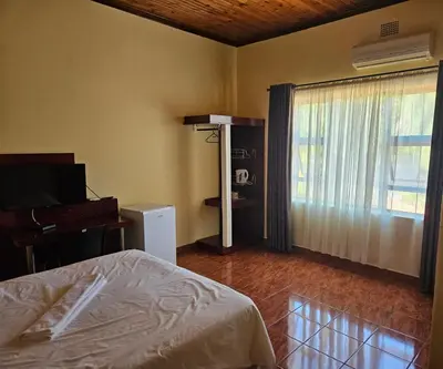 a bedroom with a bed and a large window at Marandela Guesthouse in Louis Trichardt