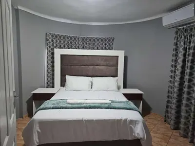 a bedroom with a large bed in a room at Marandela Guesthouse in Louis Trichardt