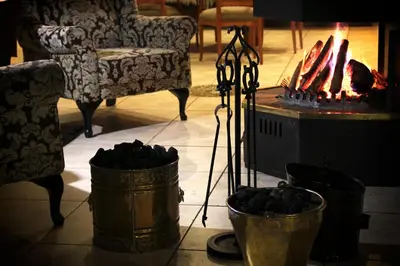 a living room with a fireplace and a couch at De Zoete Rust Guesthouse in Centurion