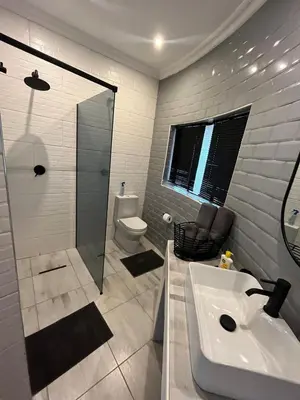 a bathroom with a sink and a shower and a toilet at Wildevy at Benlize in Hartbeespoort