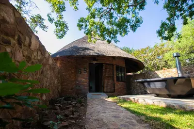 an outside view of a brick building with a thatch roof at Wildevy at Benlize in Hartbeespoort