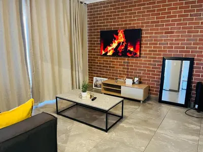 a living room with a fire in a brick wall at Secure 1 Bedroom Apartment in Midrand, Waterfall City - Lock Up and Go - Free WIFI and Parking - 5 Elizabeth Place in Midrand