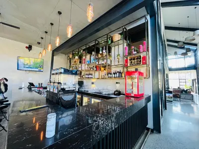 a bar in a restaurant with a red refrigerator at Secure 1 Bedroom Apartment in Midrand, Waterfall City - Lock Up and Go - Free WIFI and Parking - 5 Elizabeth Place in Midrand