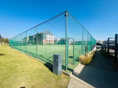 a tennis court with a net on a field at Secure 1 Bedroom Apartment in Midrand, Waterfall City - Lock Up and Go - Free WIFI and Parking - 5 Elizabeth Place in Midrand