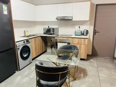 a kitchen with a washing machine and a dishwasher at Secure 1 Bedroom Apartment in Midrand, Waterfall City - Lock Up and Go - Free WIFI and Parking - 7 Elizabeth Place in Midrand