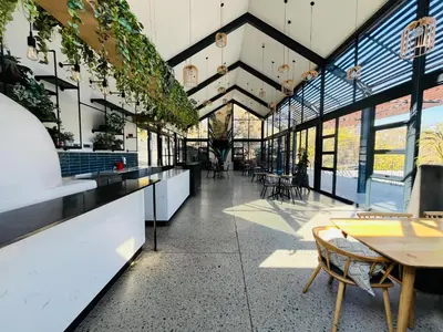 a large building with tables and chairs and windows at Spacious 2 Bedroom Apartment in Midrand, Waterfall City - Business and Family friendly - 10 Elizabeth Place in Midrand