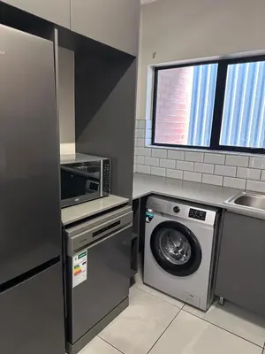 a kitchen with a washing machine and a microwave at Large 3 Bedroom Apartment in Midrand, Waterfall City - More space than a hotel room - Ideal for families, groups and work trips - 15 Elizabeth Place in Midrand