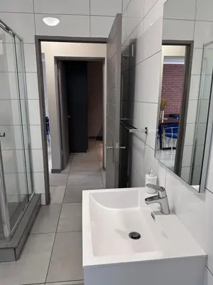 a bathroom with a white sink and a mirror at Large 3 Bedroom Apartment in Midrand, Waterfall City - More space than a hotel room - Ideal for families, groups and work trips - 15 Elizabeth Place in Midrand