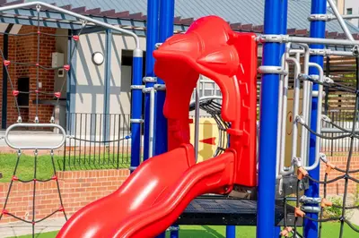 a red slide on a playground at Large 3 Bedroom Apartment in Midrand, Waterfall City - More space than a hotel room - Ideal for families, groups and work trips - 15 Elizabeth Place in Midrand