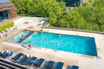 an overhead view of a swimming pool with people in it at Large 3 Bedroom Apartment in Midrand, Waterfall City - More space than a hotel room - Ideal for families, groups and work trips - 15 Elizabeth Place in Midrand