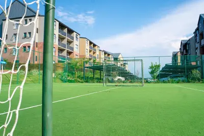 a soccer net on a tennis court in front of a building at Large 3 Bedroom Apartment in Midrand, Waterfall City - More space than a hotel room - Ideal for families, groups and work trips - 15 Elizabeth Place in Midrand