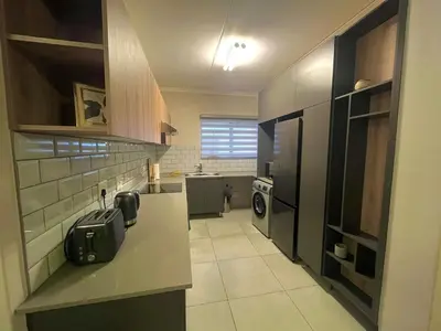 a kitchen with a suitcase sitting on the counter at Large 3 Bedroom Apartment in Midrand, Waterfall City - More space than a hotel room - Ideal for families, groups and work trips - 16 Elizabeth Place in Midrand