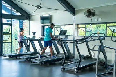 a man and a woman walking on treadmill in a gym at Large 3 Bedroom Apartment in Midrand, Waterfall City - More space than a hotel room - Ideal for families, groups and work trips - 16 Elizabeth Place in Midrand