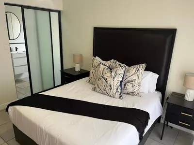 a bedroom with a bed with a black headboard and pillows at Large 3 Bedroom Apartment in Midrand, Waterfall City - More space than a hotel room - Ideal for families, groups and work trips - 17 Elizabeth Place in Midrand