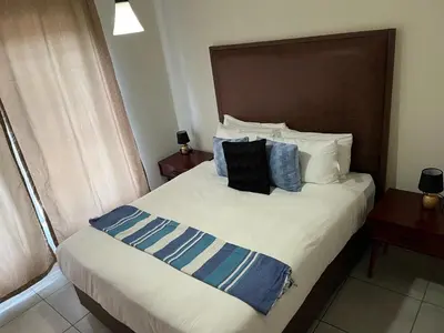 a bedroom with a large bed with blue and white pillows at Large 3 Bedroom Apartment in Midrand, Waterfall City - More space than a hotel room - Ideal for families, groups and work trips - 17 Elizabeth Place in Midrand