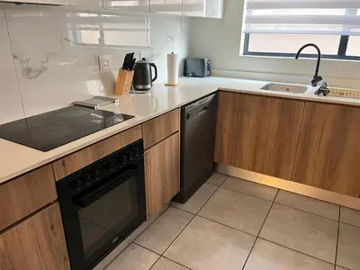 a kitchen with a stove and a dishwasher at Large 3 Bedroom Apartment in Midrand, Waterfall City - More space than a hotel room - Ideal for families, groups and work trips - 17 Elizabeth Place in Midrand