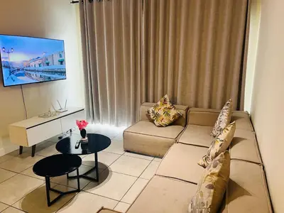 a living room with a couch and a table at Large 3 Bedroom Apartment in Midrand, Waterfall City - More space than a hotel room - Ideal for families, groups and work trips - 17 Elizabeth Place in Midrand