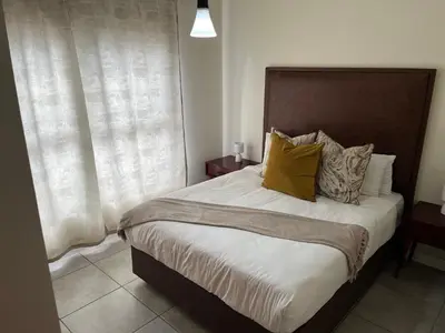 a bedroom with a large bed with yellow pillows at Large 3 Bedroom Apartment in Midrand, Waterfall City - More space than a hotel room - Ideal for families, groups and work trips - 17 Elizabeth Place in Midrand