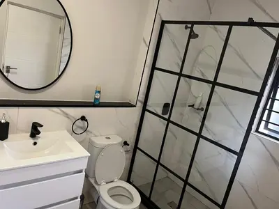 a bathroom with a shower and a toilet and a sink at Large 3 Bedroom Apartment in Midrand, Waterfall City - More space than a hotel room - Ideal for families, groups and work trips - 17 Elizabeth Place in Midrand