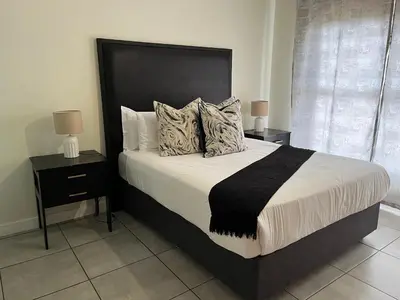 a bedroom with a large bed with two night stands at Large 3 Bedroom Apartment in Midrand, Waterfall City - More space than a hotel room - Ideal for families, groups and work trips - 17 Elizabeth Place in Midrand
