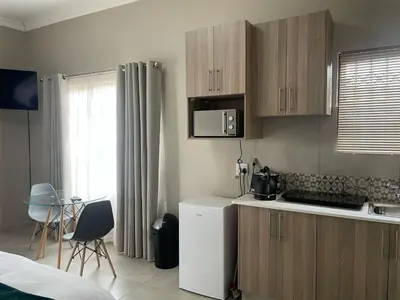 a kitchen with wooden cabinets and a counter top at Oaktree in Ermelo