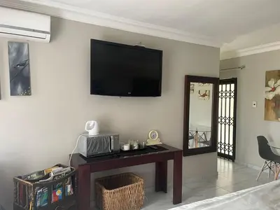 a living room with a flat screen tv on the wall at Oaktree in Ermelo