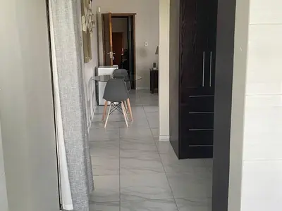 a hallway with a tile floor and a table at Oaktree in Ermelo