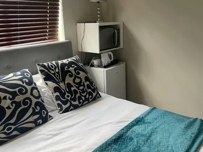 a bedroom with a bed with a tv and pillows at Oaktree in Ermelo