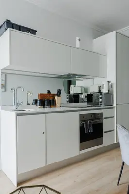 a white kitchen with a sink and a stove at Elipse Waterfall-2803 in Midrand