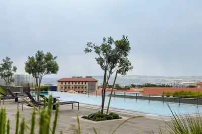 a swimming pool with a tree and a building at Elipse Waterfall-2803 in Midrand
