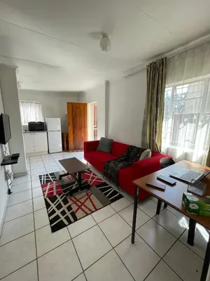 a living room with a red couch and a table at Smartshelter Park in Pretoria