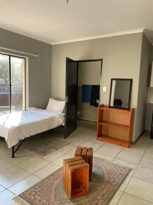 a bedroom with a bed and a table and a mirror at Smartshelter Park in Pretoria