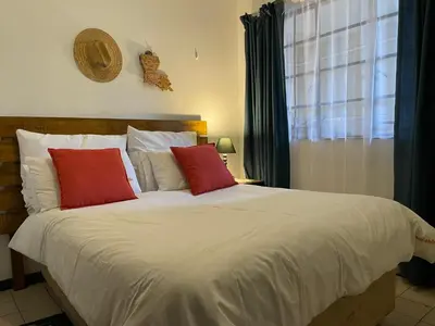a bed with two red pillows in a bedroom at Smartshelter Park in Pretoria