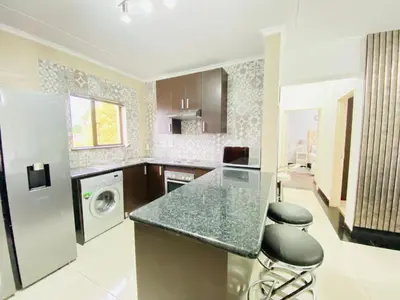 a kitchen with a counter and a washer and dryer at Siena Sun Apartment 8 in Midrand