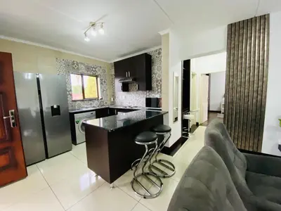 a kitchen with a bar and a couch in a room at Siena Sun Apartment 8 in Midrand