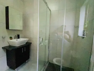 a person taking a picture of a bathroom with a shower at Siena Sun Apartment 8 in Midrand
