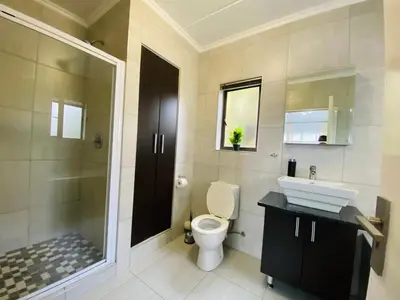 a bathroom with a toilet and a sink and a shower at Siena Sun Apartment 8 in Midrand
