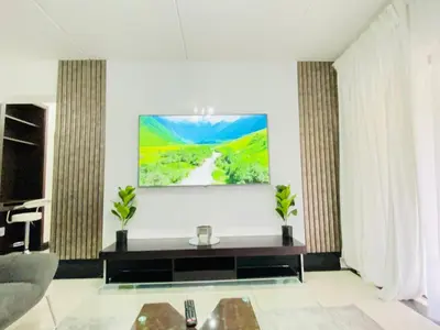 a living room with a large painting on the wall at Siena Sun Apartment 8 in Midrand