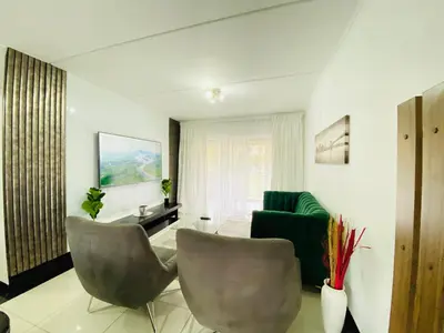 a living room with two chairs and a couch at Siena Sun Apartment 8 in Midrand