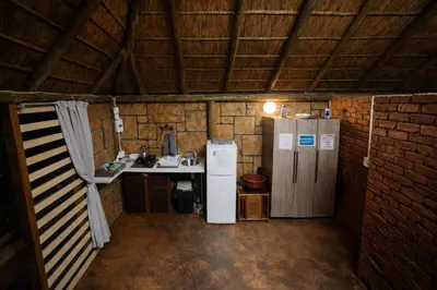 a kitchen with a refrigerator and a sink in a room at 5 Sleeper Bushcamp Chalet Hartbeespoort in Hartbeespoort