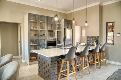 a kitchen with a large island with bar stools at Highland Gate Eagles Breeze in Dullstroom
