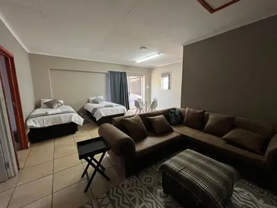 a living room with a couch and a bed at 1 on Titania in Polokwane