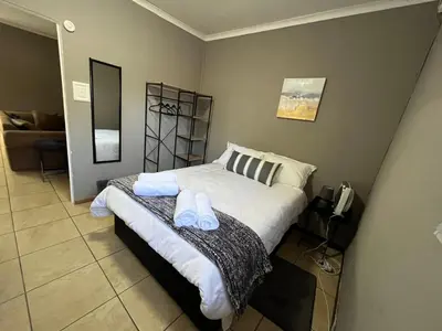 a bedroom with a bed with two towels on it at 1 on Titania in Polokwane