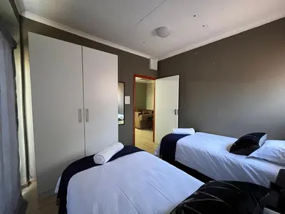 a hotel room with two beds and a closet at 1 on Titania in Polokwane