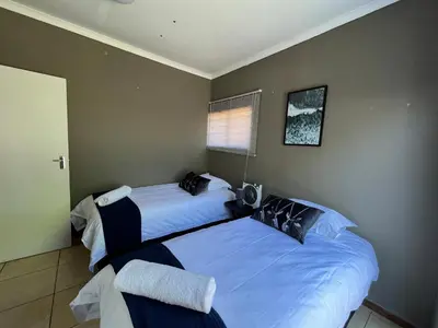 a bedroom with two beds and a window at 1 on Titania in Polokwane