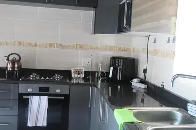 a kitchen with a sink and a stove top oven at Kruger Nest in Marloth Park